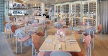 A pastel dining room setting with a wine cellar