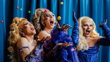 three drag queens throwing bingo balls